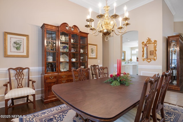 dining space featuring sink, dark hardwood / wood-style flooring, ornamental molding, and an inviting chandelier