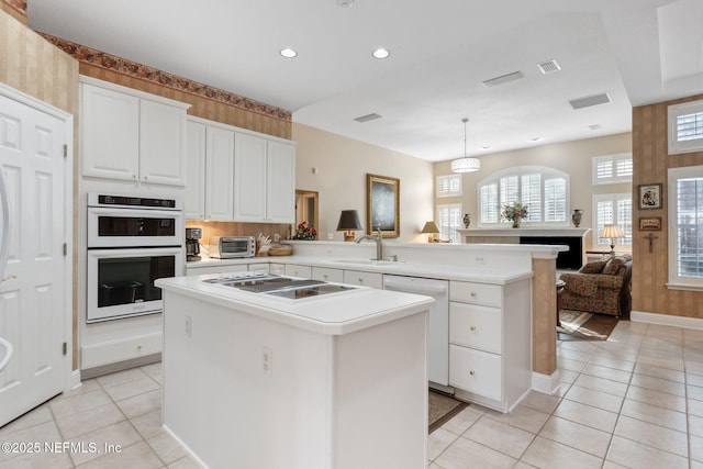 kitchen with white appliances, a kitchen island, decorative light fixtures, white cabinetry, and kitchen peninsula