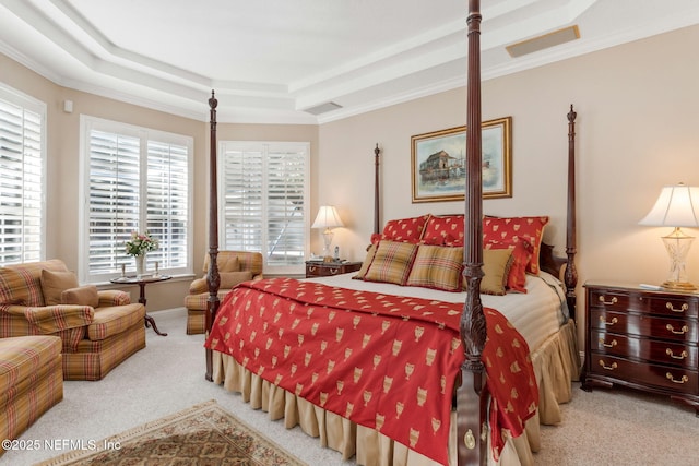 bedroom with a tray ceiling, ornamental molding, and light carpet