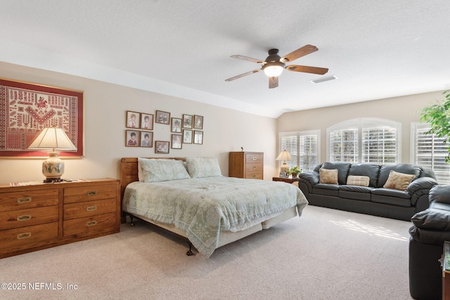 carpeted bedroom with ceiling fan, vaulted ceiling, and a textured ceiling