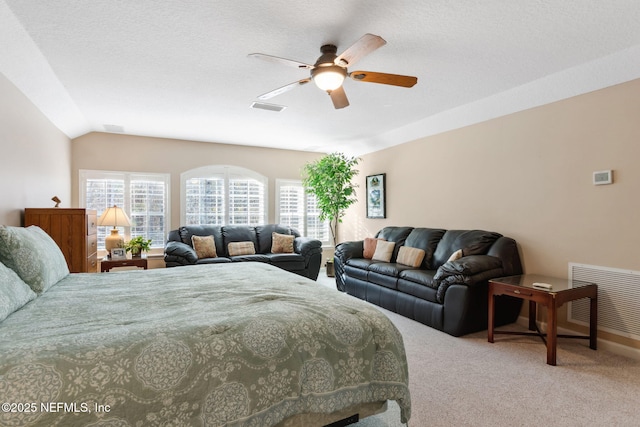 bedroom with ceiling fan, a textured ceiling, carpet floors, and vaulted ceiling