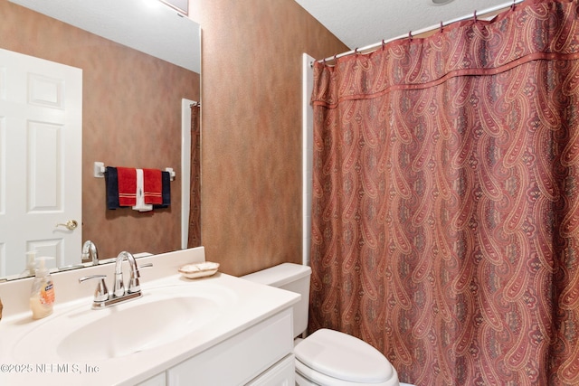 bathroom with a textured ceiling, toilet, and vanity