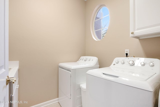 clothes washing area featuring washer and clothes dryer and cabinets