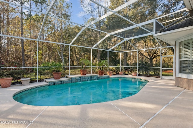 view of swimming pool with glass enclosure and a patio area