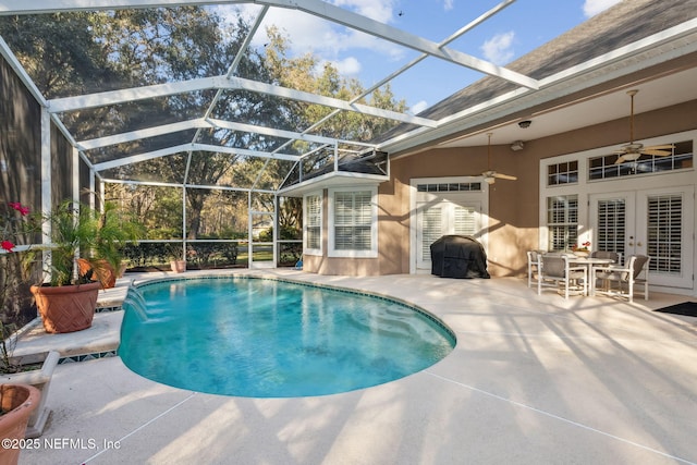 view of pool with ceiling fan, a lanai, pool water feature, and a patio area