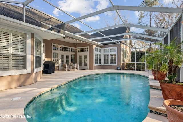 view of swimming pool with glass enclosure, a patio area, french doors, pool water feature, and area for grilling