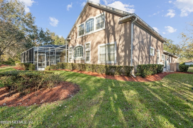 view of side of home featuring glass enclosure and a lawn