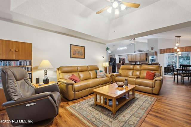 living room with high vaulted ceiling, ceiling fan, and hardwood / wood-style flooring