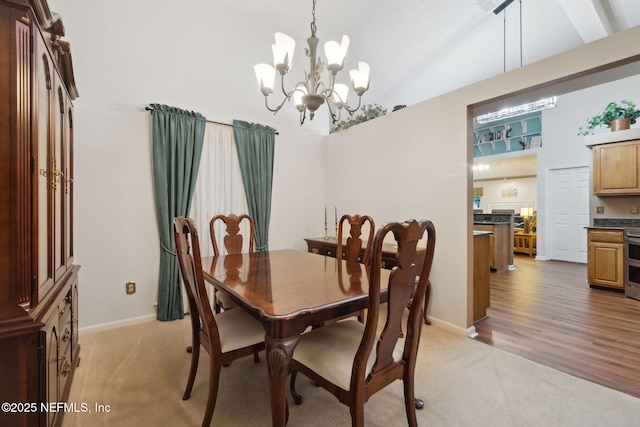 carpeted dining room with high vaulted ceiling and a chandelier