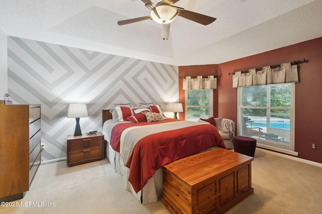 carpeted bedroom with ceiling fan and a textured ceiling