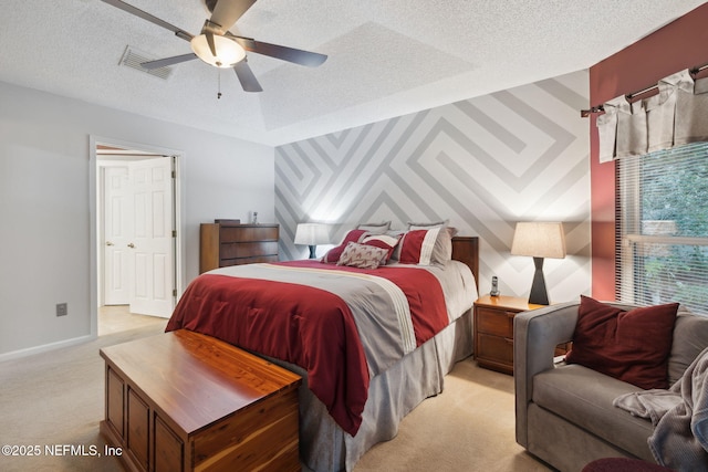 bedroom with a textured ceiling, ceiling fan, and light colored carpet