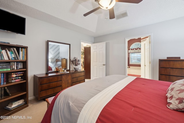 bedroom with ceiling fan, a textured ceiling, carpet floors, and ensuite bath