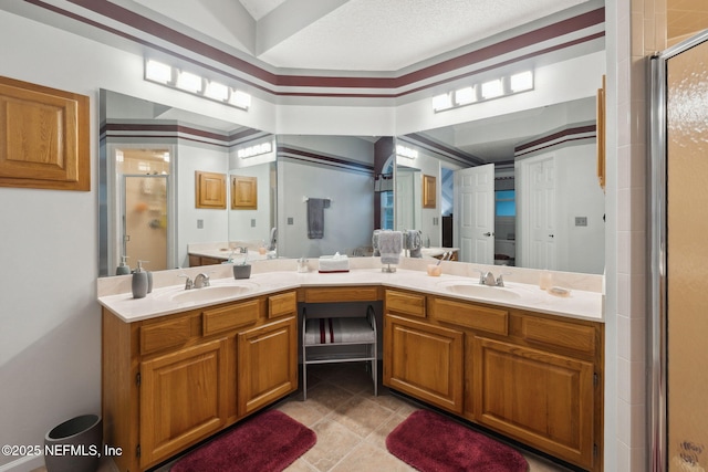 bathroom featuring a shower with shower door and vanity