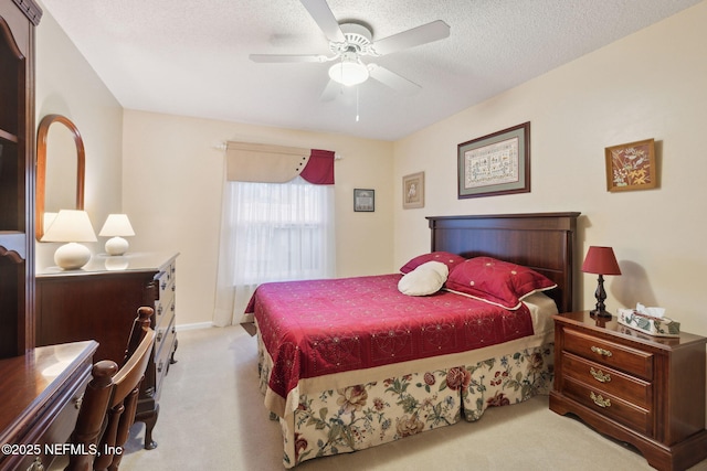 bedroom featuring a textured ceiling, ceiling fan, and light colored carpet