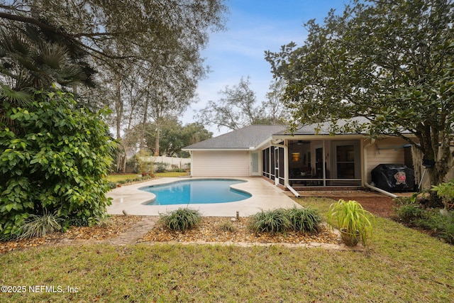 view of pool with a patio area, a sunroom, and a yard