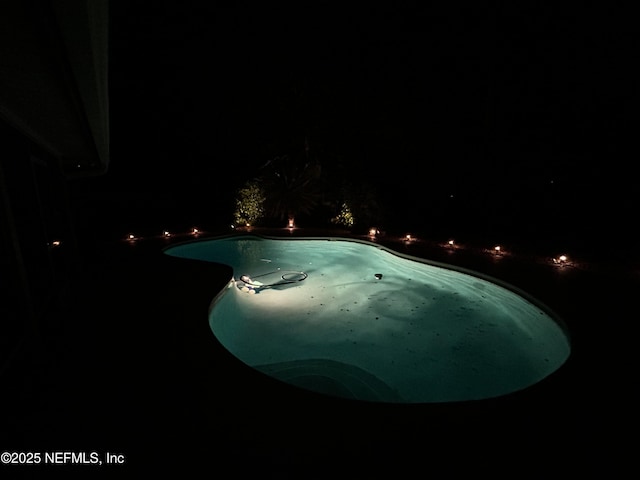 view of pool at twilight