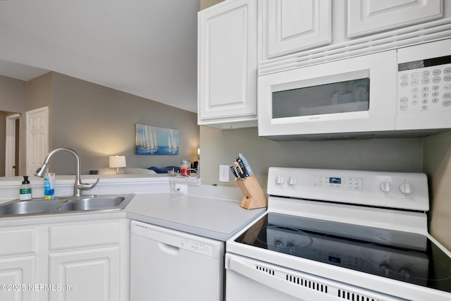 kitchen with kitchen peninsula, sink, white cabinets, and white appliances