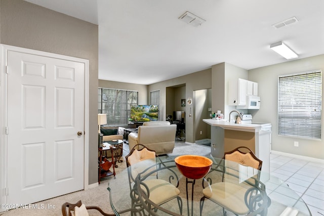 living room with sink, light tile patterned flooring, and a healthy amount of sunlight