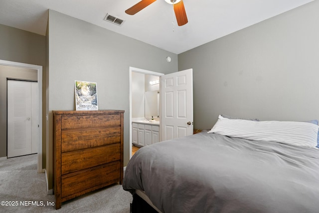 carpeted bedroom with ceiling fan, a closet, and ensuite bath