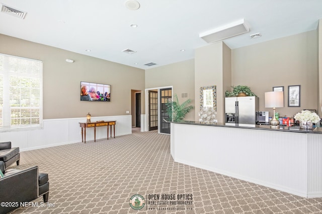 kitchen with stainless steel fridge with ice dispenser and light carpet