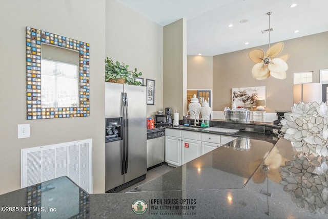 kitchen featuring kitchen peninsula, stainless steel appliances, ceiling fan, sink, and white cabinetry