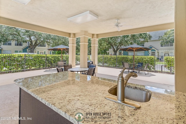 view of patio with ceiling fan and sink