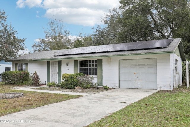 single story home with solar panels, a garage, and a front yard