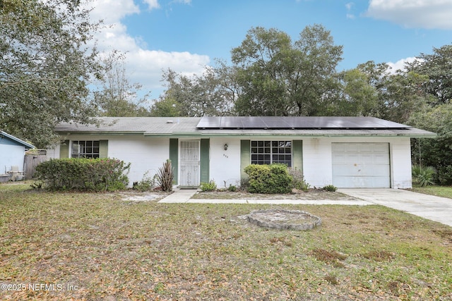 ranch-style house featuring solar panels, a front yard, and a garage