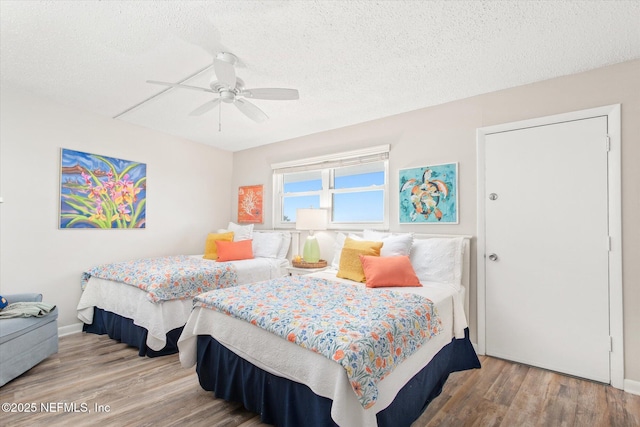 bedroom with wood-type flooring, a textured ceiling, and ceiling fan