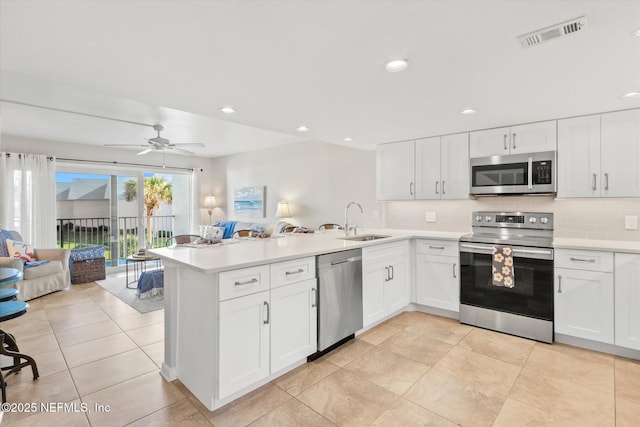 kitchen with stainless steel appliances, white cabinetry, and sink