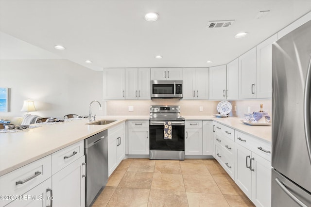 kitchen with backsplash, sink, white cabinets, and appliances with stainless steel finishes