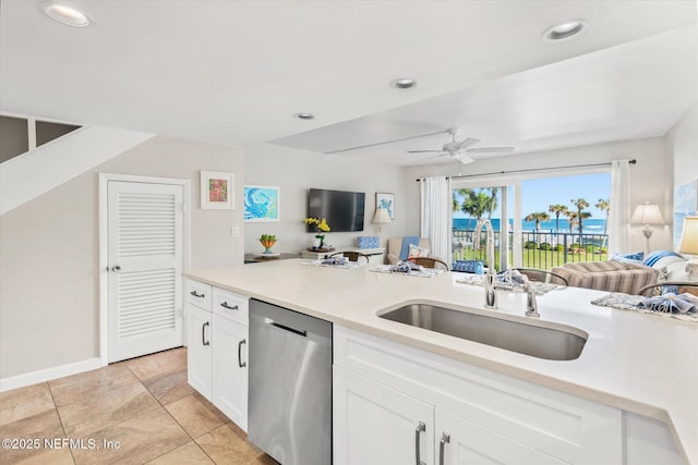 kitchen with sink, stainless steel dishwasher, ceiling fan, light tile patterned flooring, and white cabinetry