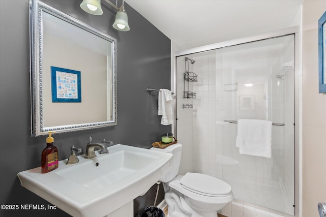 bathroom with sink, an enclosed shower, and toilet