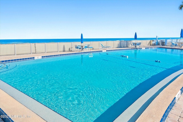 view of pool featuring a patio area and a water view