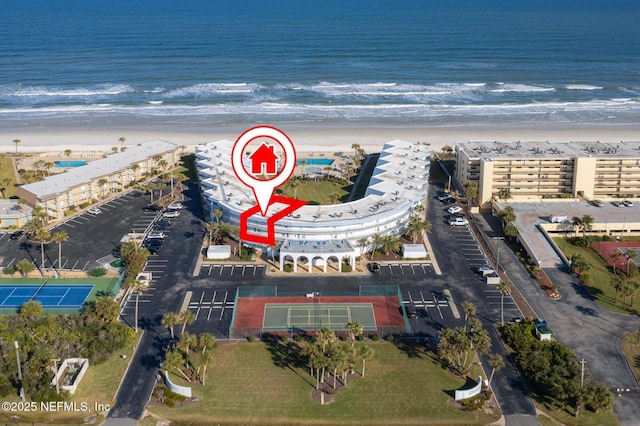 birds eye view of property with a water view and a view of the beach