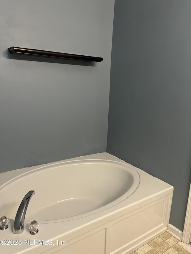 bathroom with tile patterned flooring and a bath