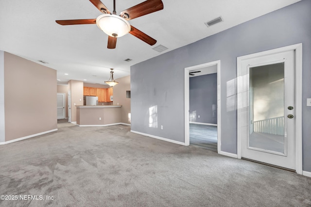 unfurnished living room with ceiling fan and light carpet