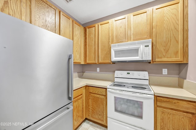 kitchen with light brown cabinets and white appliances