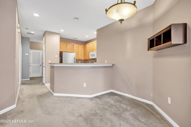 kitchen with light colored carpet, light brown cabinetry, kitchen peninsula, and stainless steel refrigerator