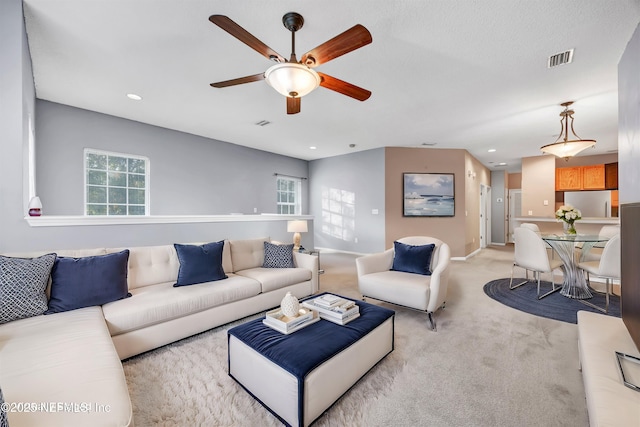 carpeted living room with ceiling fan