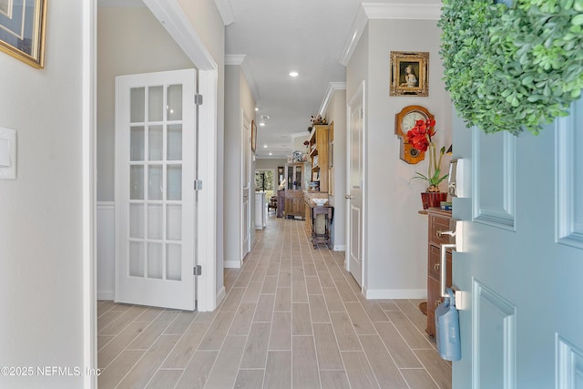 corridor featuring ornamental molding and light hardwood / wood-style flooring