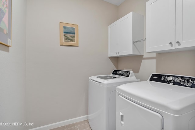 washroom featuring washer and clothes dryer, light tile patterned floors, and cabinets