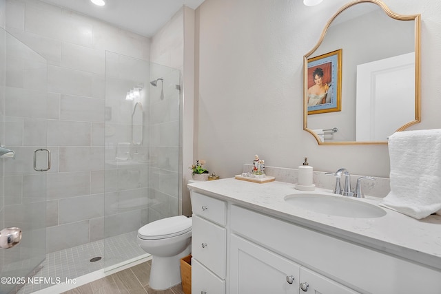 bathroom with vanity, toilet, and a shower with shower door