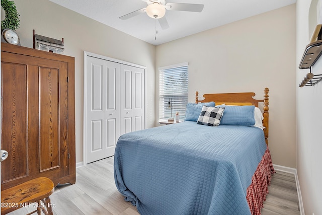 bedroom with ceiling fan, light hardwood / wood-style flooring, and a closet