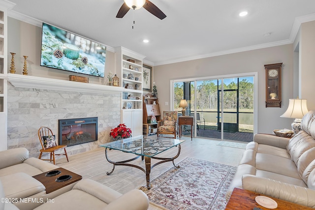 living room featuring a stone fireplace, ceiling fan, and ornamental molding