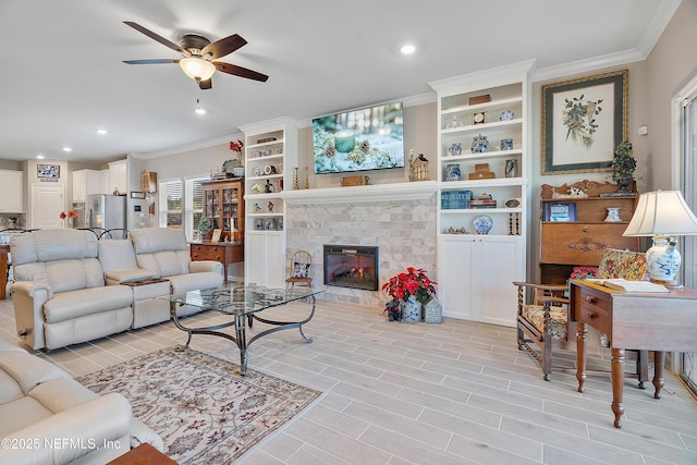 living room featuring ceiling fan, ornamental molding, and a fireplace