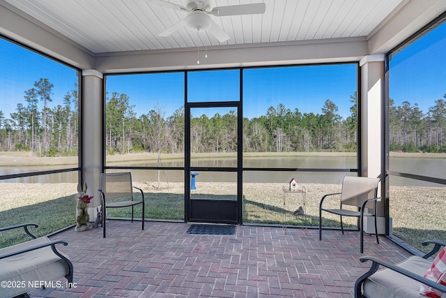 sunroom / solarium with ceiling fan and a water view