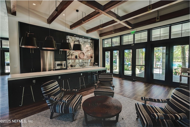 bar with dark hardwood / wood-style flooring, beamed ceiling, hanging light fixtures, and appliances with stainless steel finishes