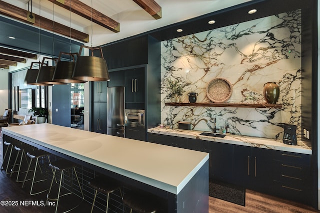 kitchen with dark hardwood / wood-style floors, built in microwave, beamed ceiling, decorative light fixtures, and stainless steel refrigerator