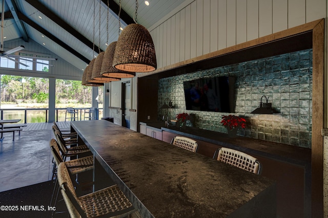 dining area featuring beam ceiling and high vaulted ceiling